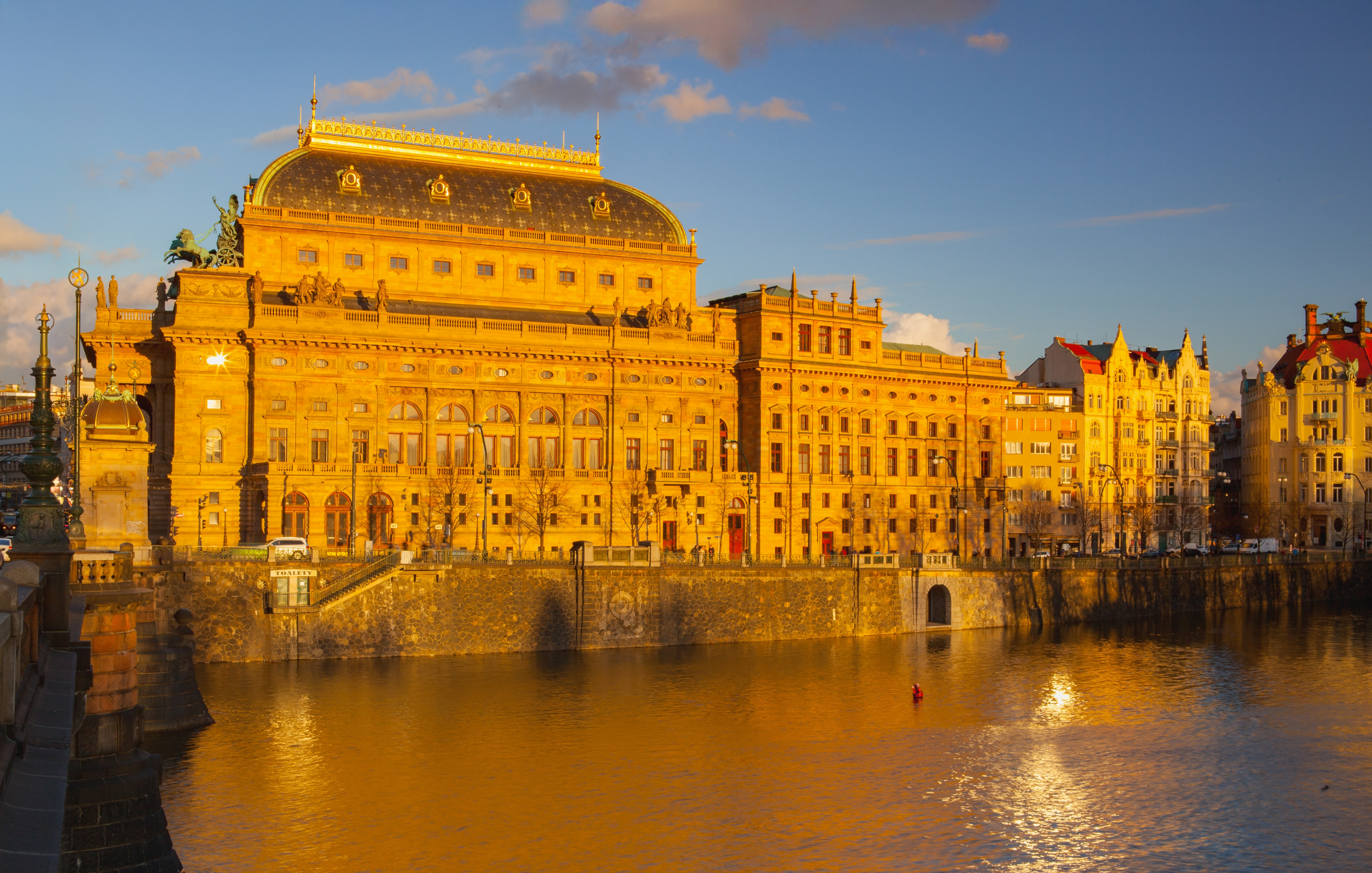 Prague National Theatre and Vltava River bridges at golden hour