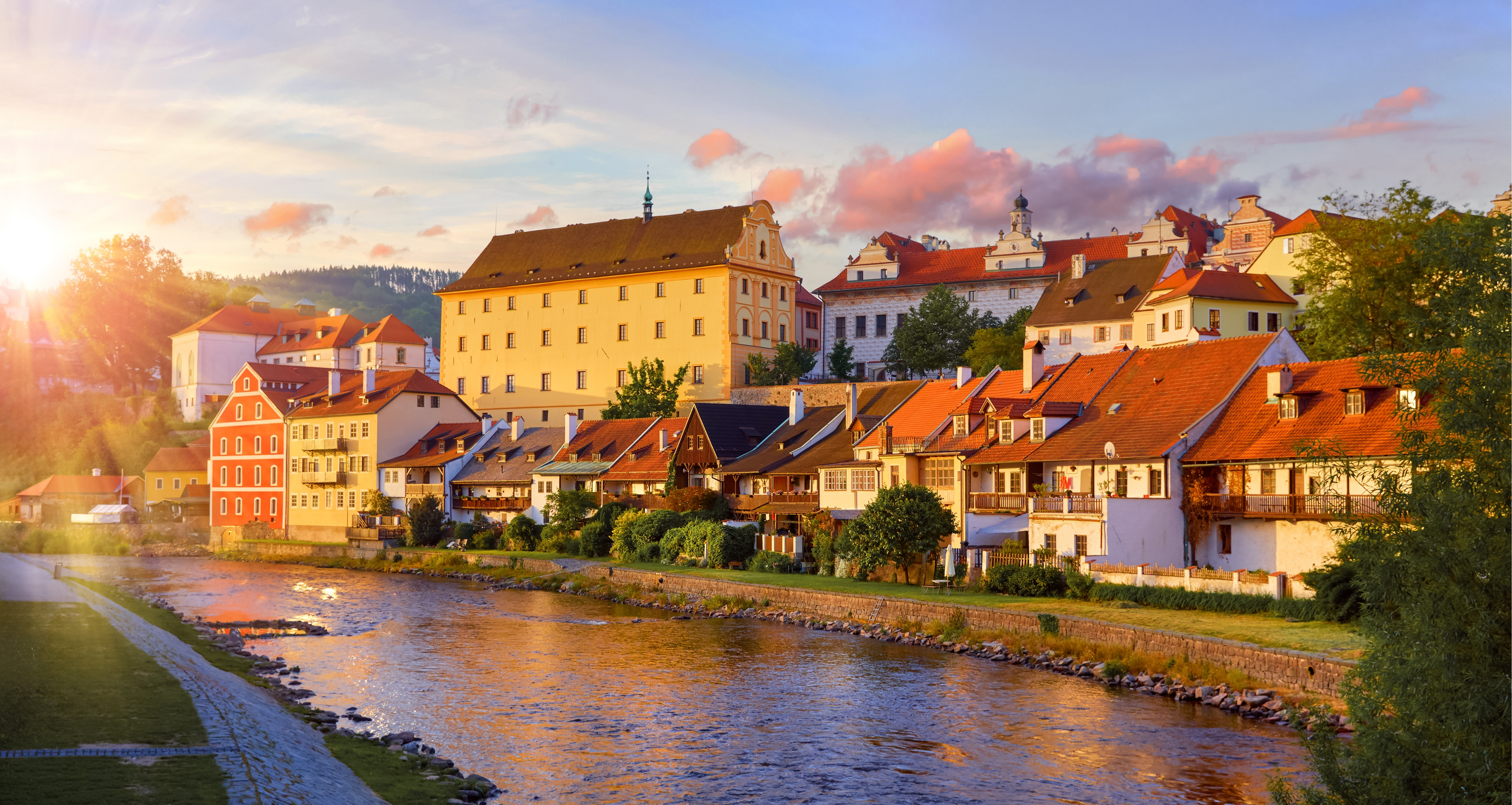 Český Krumlov historic town and castle at golden hour, view from the Vltava riverbank
