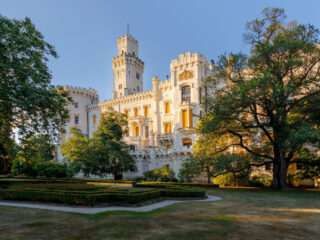 Zámek Hluboká nad Vltavou v odpoledním světle s pohledem z upraveného zámeckého parku.
