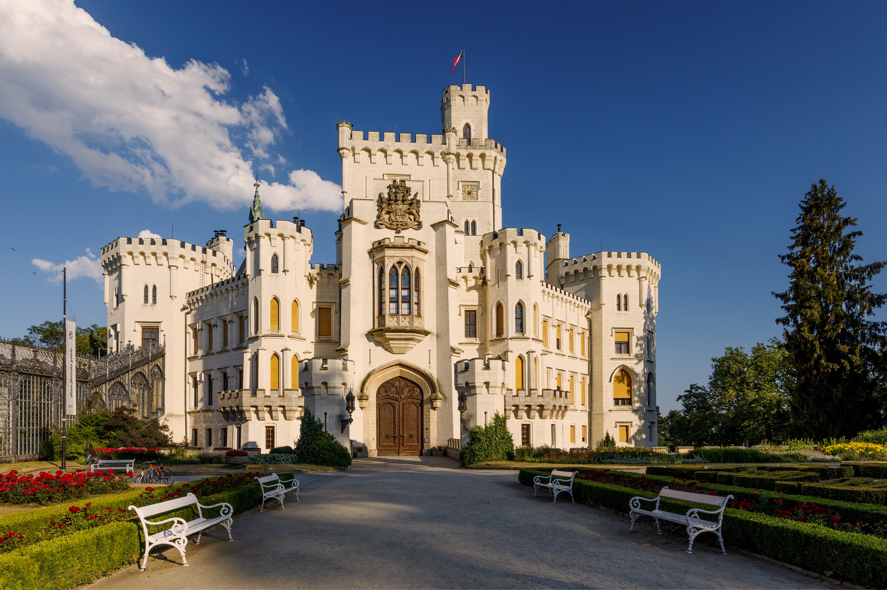 Hluboká Castle in summer daylight — view of the main entrance and castle gardens