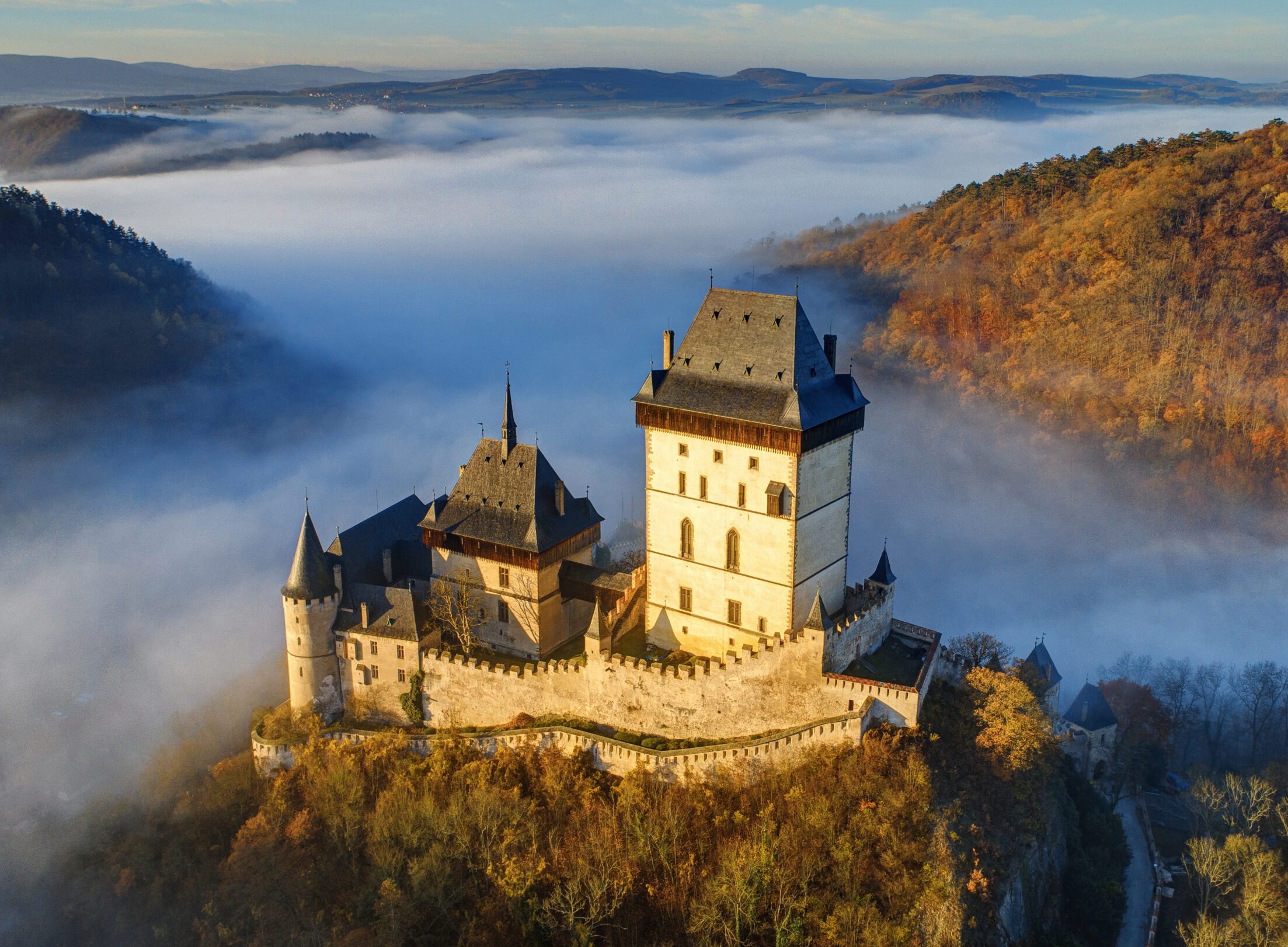Letecký pohled na hrad Karlštejn v&nbsp;jarní ranní mlze – jeden z&nbsp;nejkrásnějších hradů středních Čech