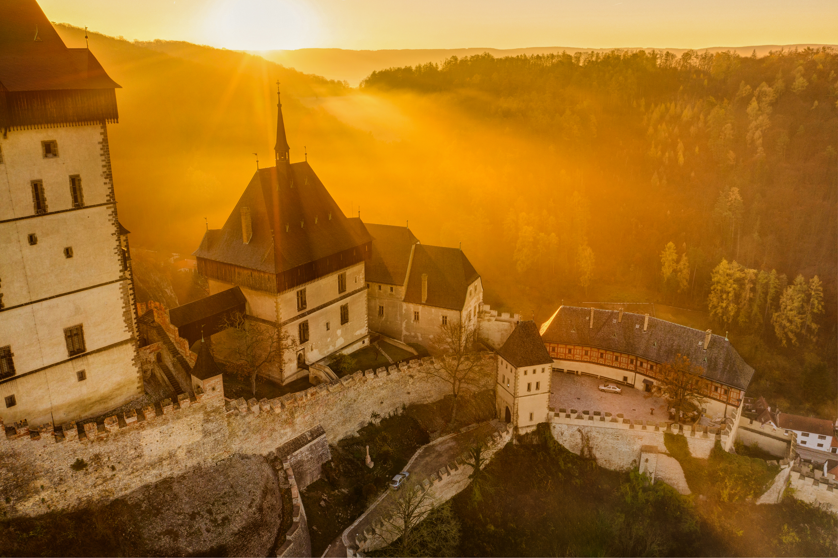 Karlštejn Castle at sunrise — aerial view over the Berounka valley