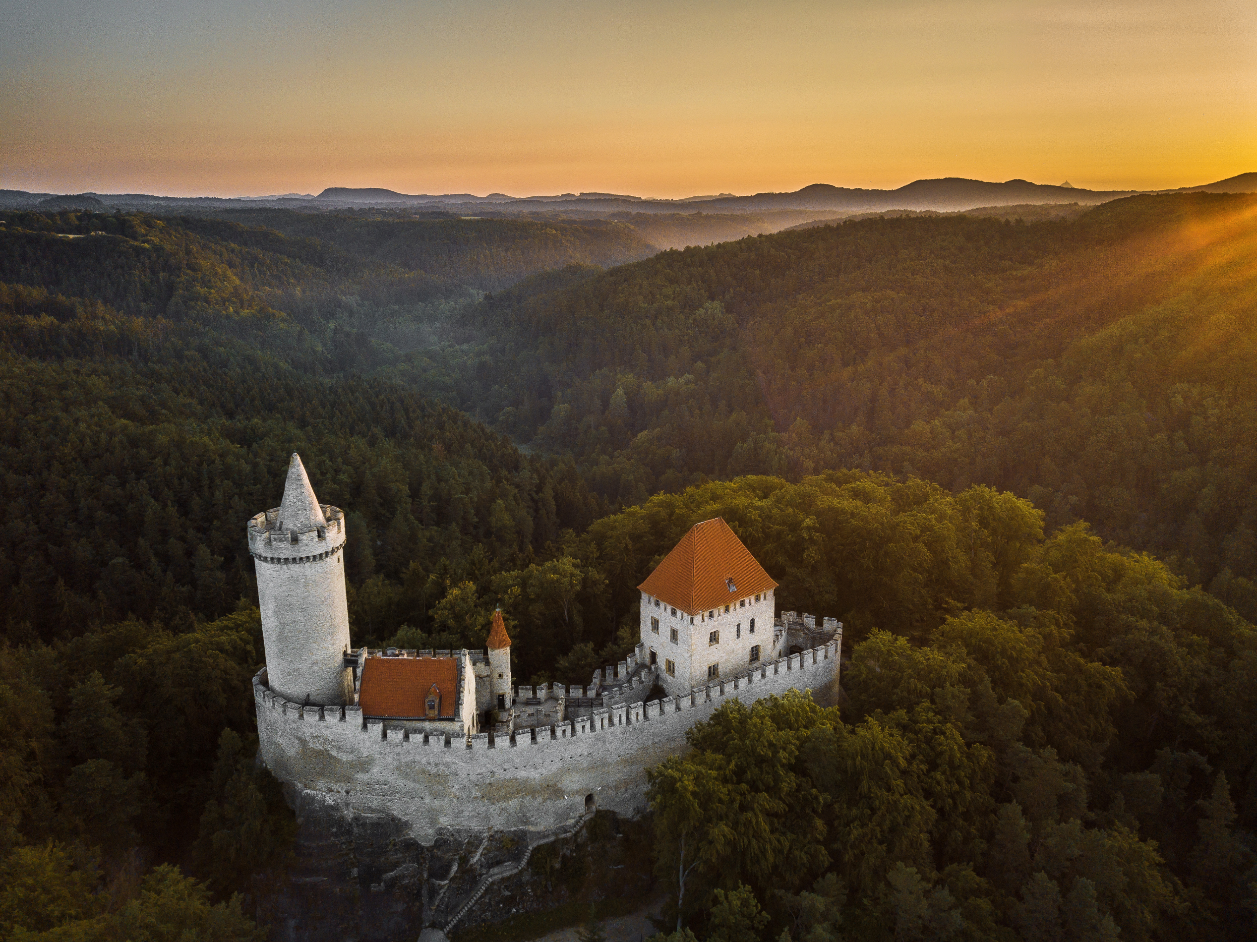 Kokorin Castle at sunset surrounded by dense forests of Kokorinsko Protected Landscape