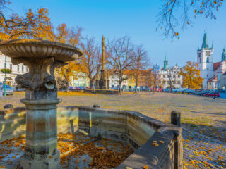 Litoměřické Mírové náměstí na podzim s historickou kašnou, mariánským sloupem a věží chrámu sv. Štěpána.