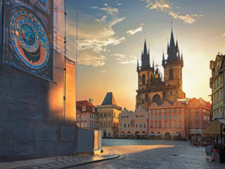 Staroměstské náměstí v Praze při východu slunce s orlojem a Týnským chrámem