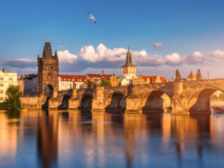 Karlův most v Praze při zlaté hodině s výhledem na Vltavu a Staroměstskou mosteckou věž