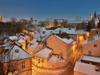 Zasněžený Nový Svět na Hradčanech v Praze během zimního večera