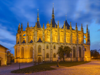 St. Barbara’s Cathedral in Kutná Hora illuminated at evening with Gothic architecture and blue hour sky