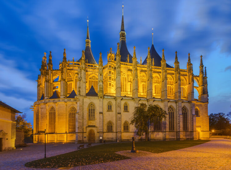 Chrám svaté Barbory v Kutné Hoře nasvícený večer s gotickou architekturou a modrou oblohou