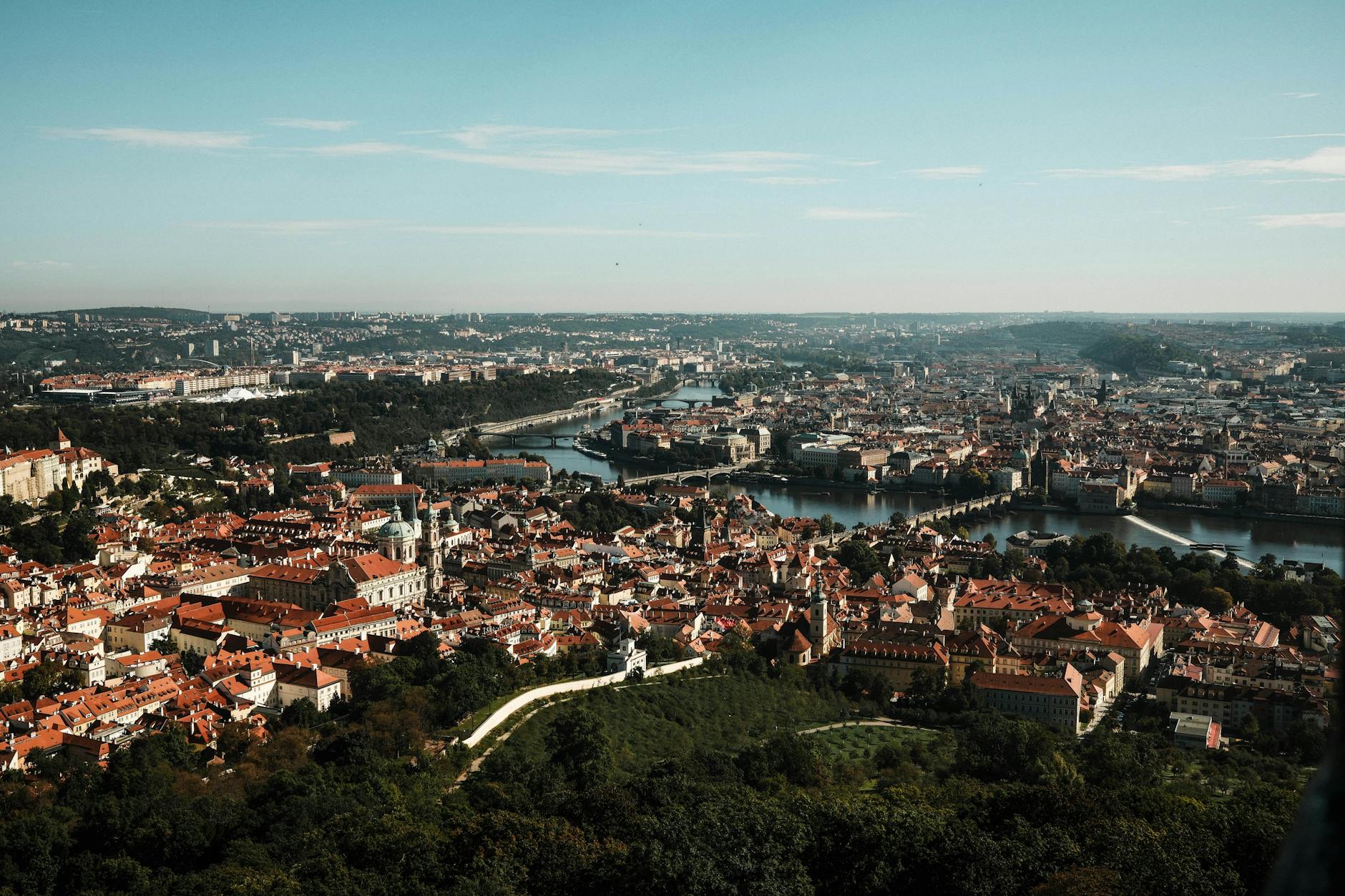Panoramatický pohled na Pražský hrad zrcadlící se ve Vltavě za soumraku