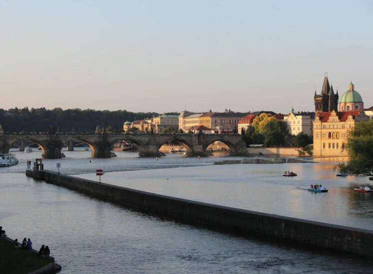 Golden sunset over Charles Bridge and Vltava River in Prague with historic Old Town skyline