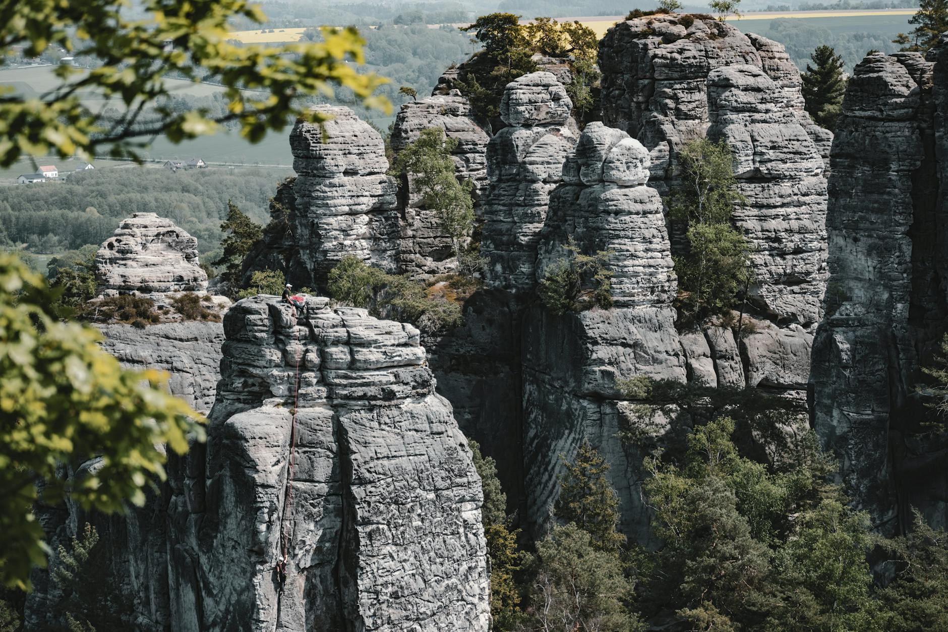 Climbers on towering sandstone rock formations at Adrspach, Czech Republic