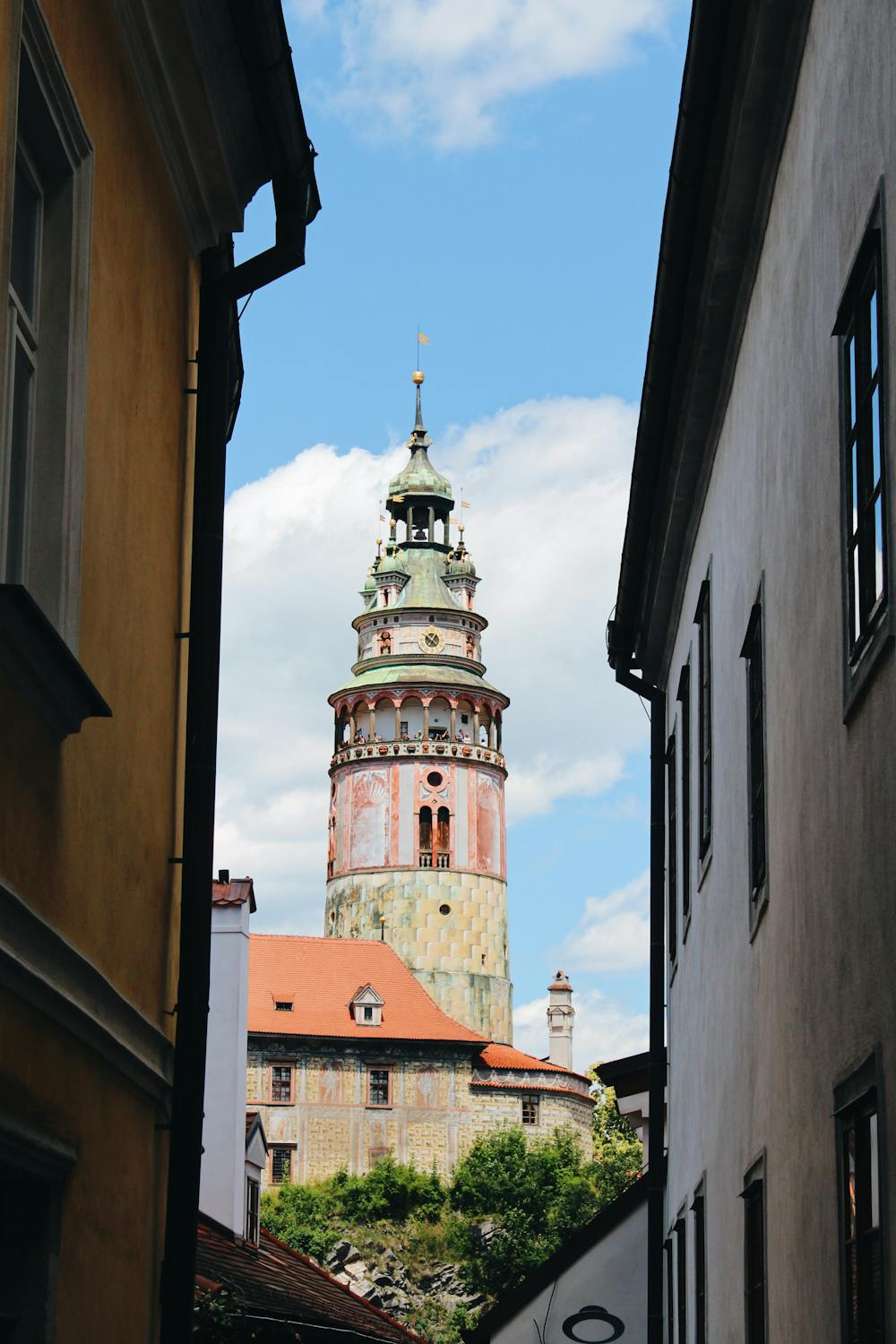 Charming cobblestone street in Český Krumlov old town with castle tower in background