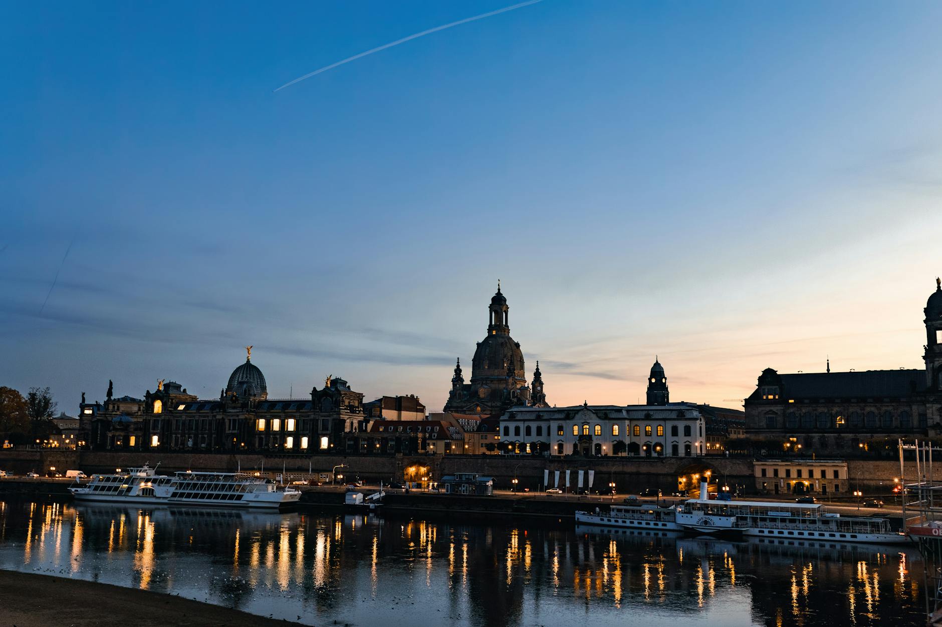 Dresden baroque skyline along the Elbe river at dusk with moored boats