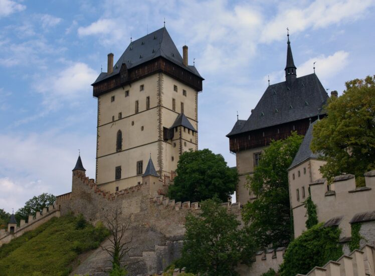 Karlstejn Castle surrounded by lush green forests in summer