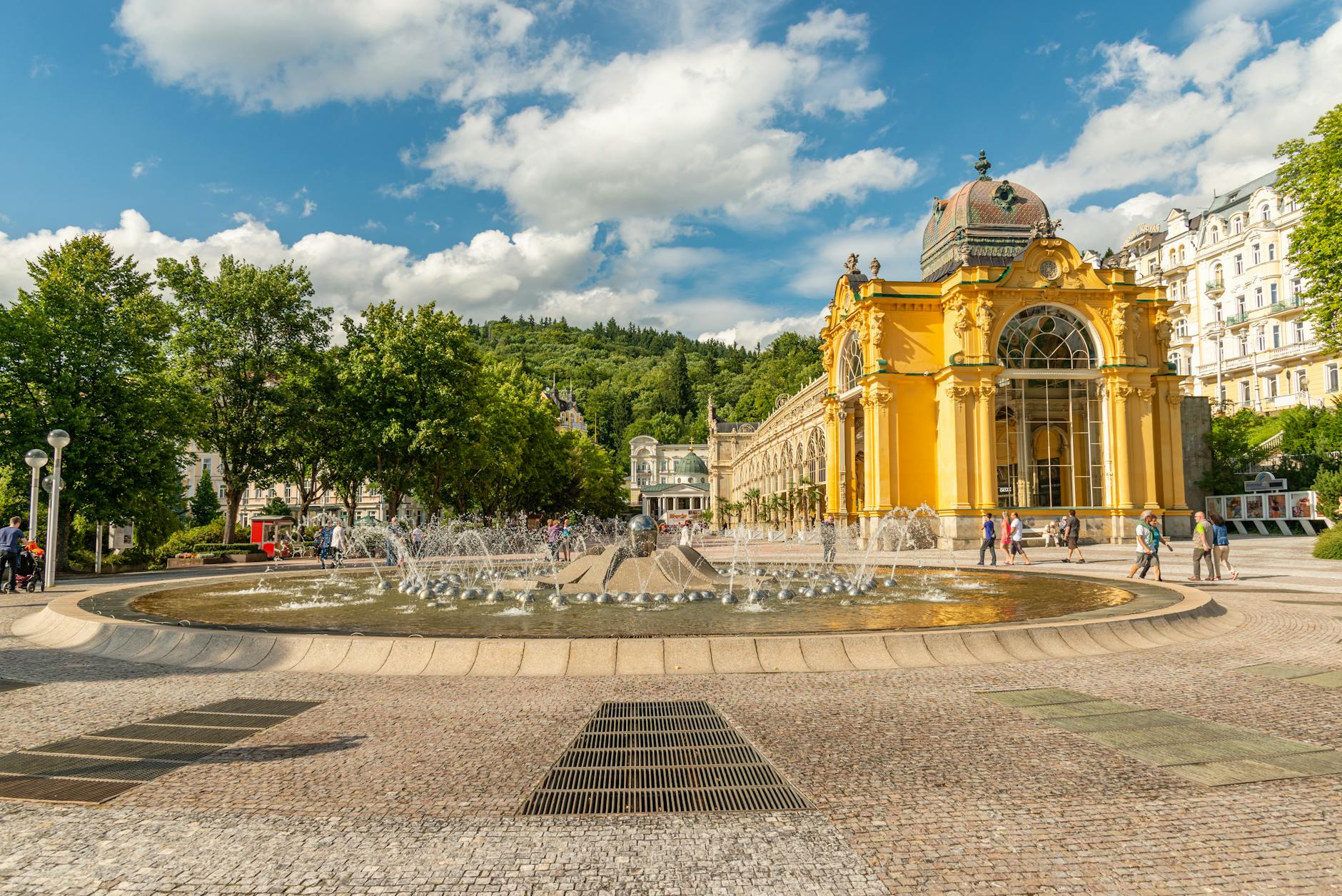 Beautiful view of the Singing Fountain and Spa Colonnade in Mariánské Lázně, surrounded by lush greenery.
