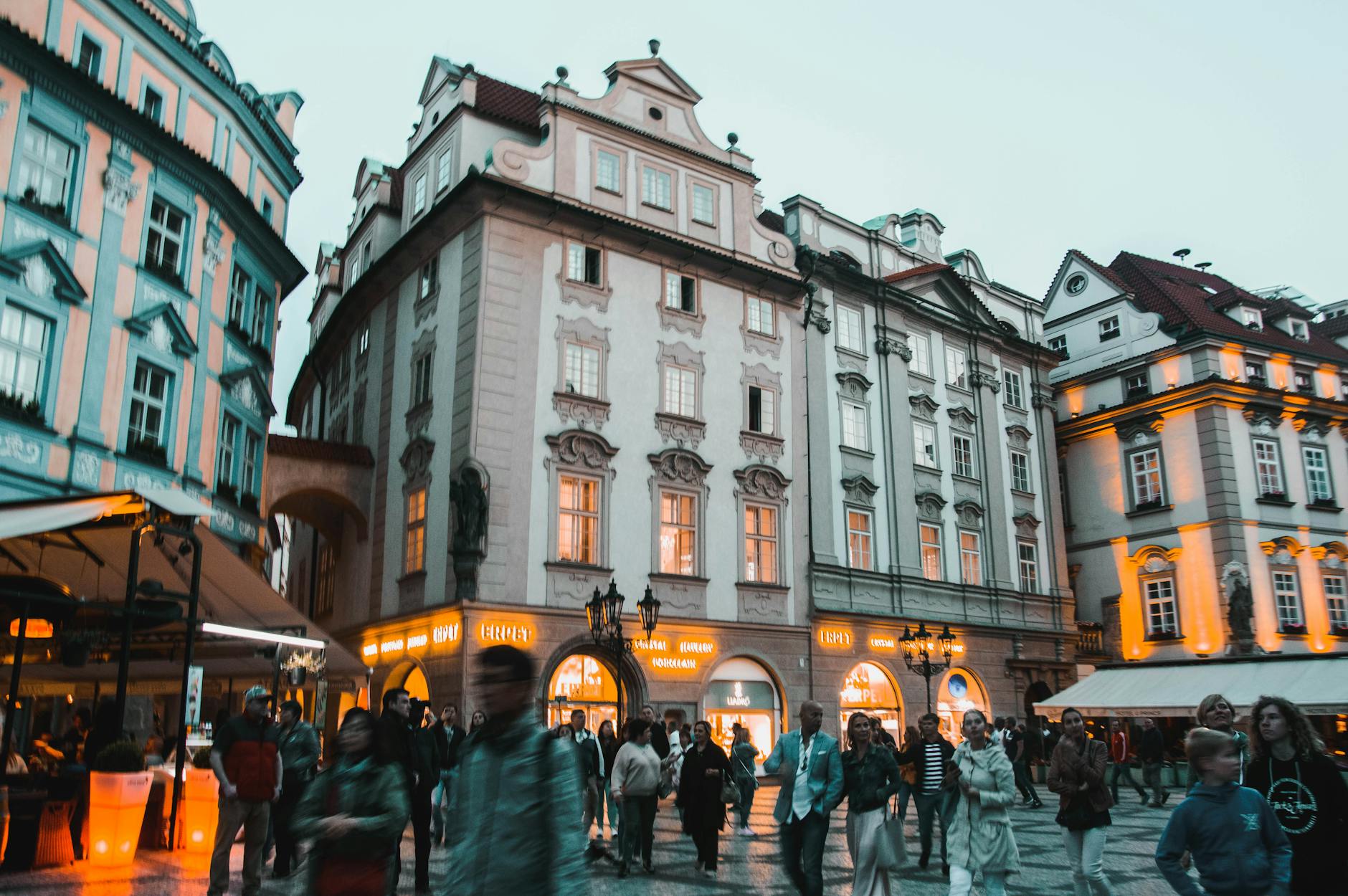 Dynamic evening scene showcasing historic Prague architecture and bustling street life.