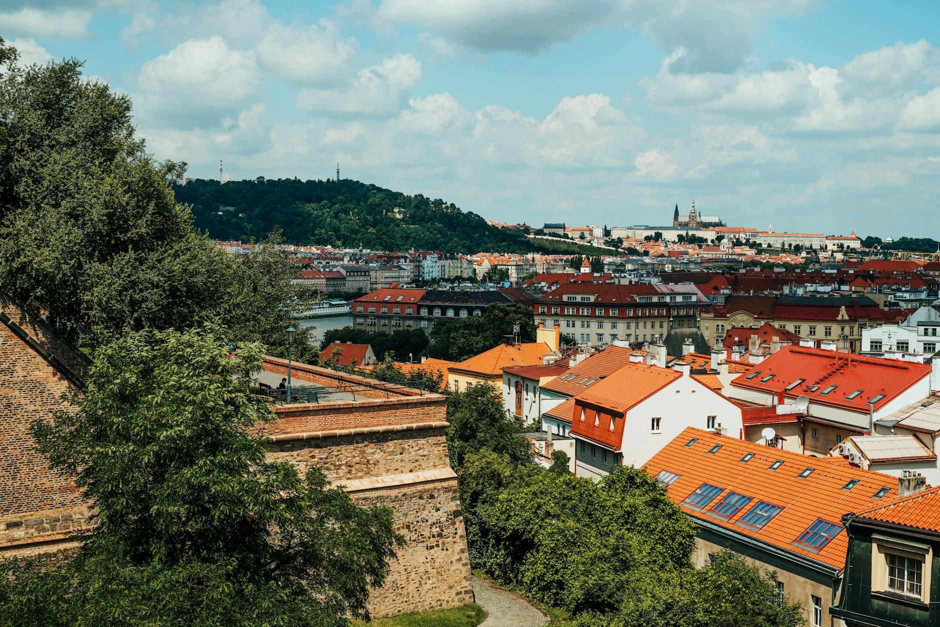 Prague city skyline with iconic red rooftops and green hills, Czech Republic