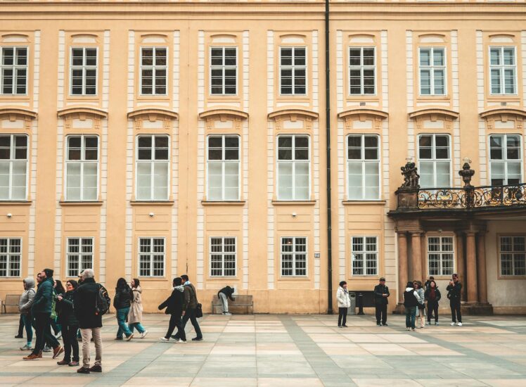 Tourists exploring a historic courtyard in Prague on a sunny day during a private city tour