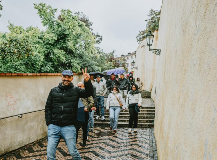 Turisté na schodech v Praze za deštivého dne