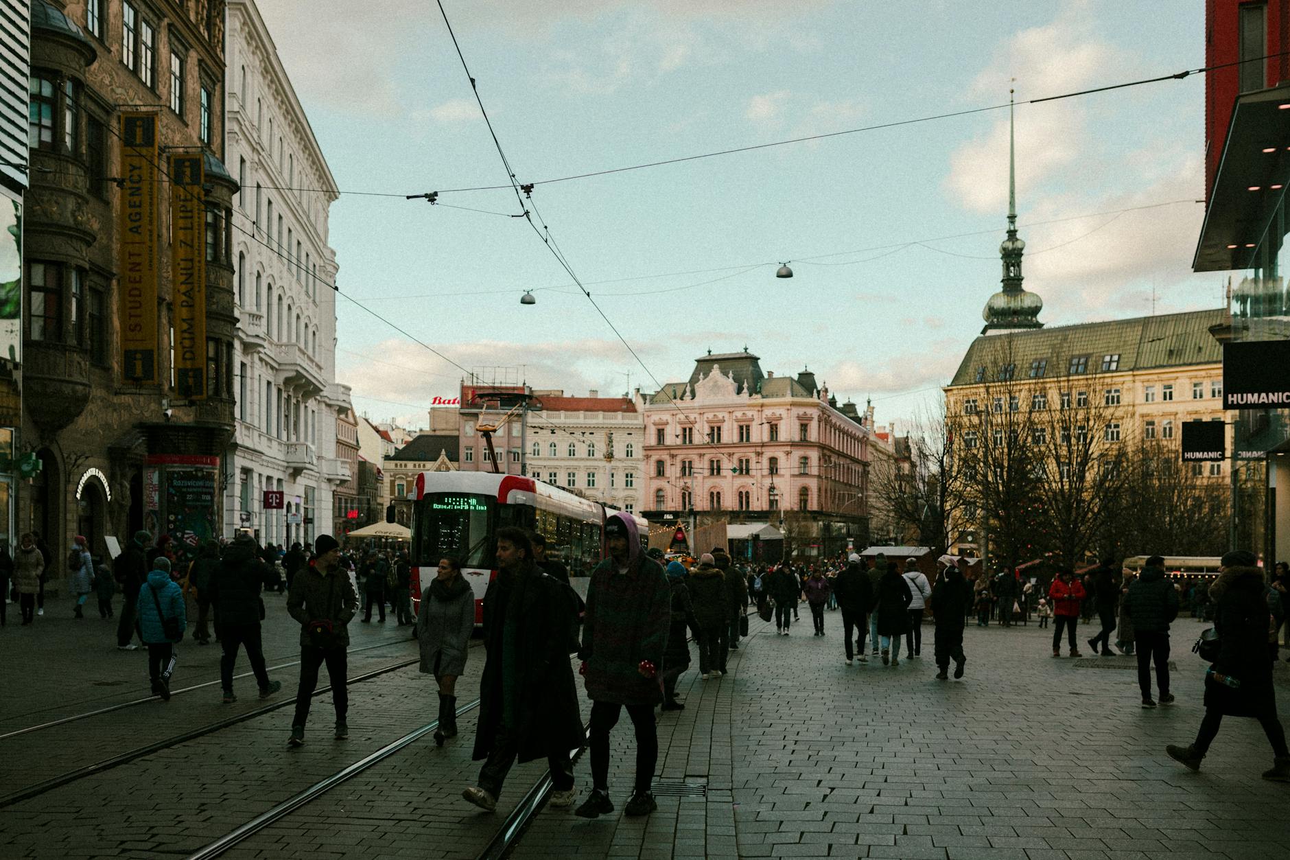 Vibrant city street view with historic buildings and people bustling about, capturing city life.